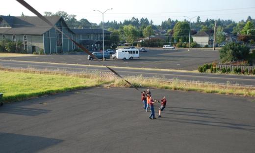 The ground crew hold the anchor line as Chris lowers the balloon to the asphalt.