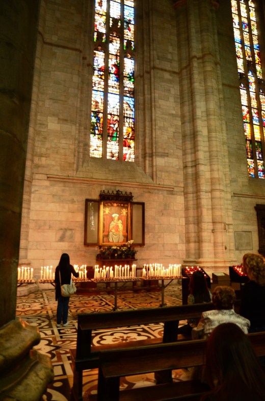 Lighting candles for Madonna con bambino